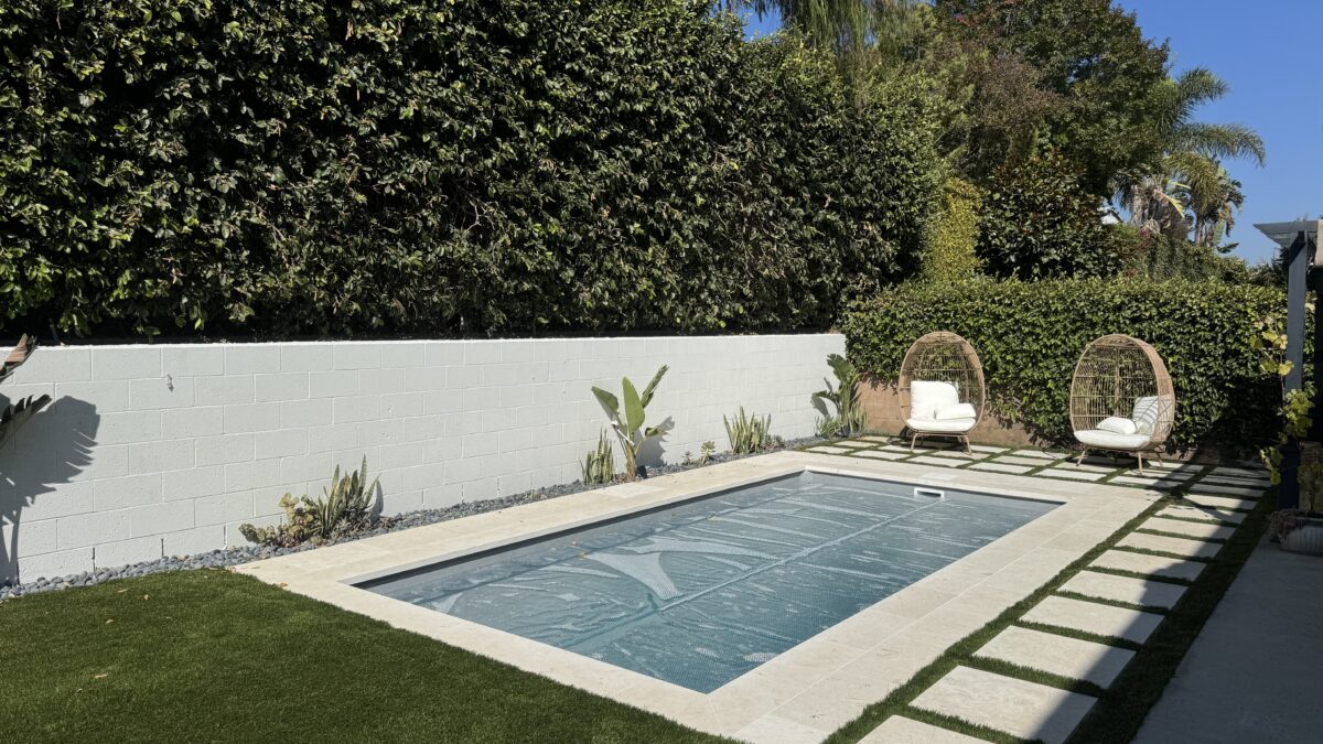 Rectangular plunge pool with a paved patio, wood fence, and separate hot tub in Ventura.