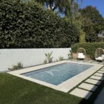 Rectangular plunge pool with a paved patio, wood fence, and separate hot tub in Ventura.