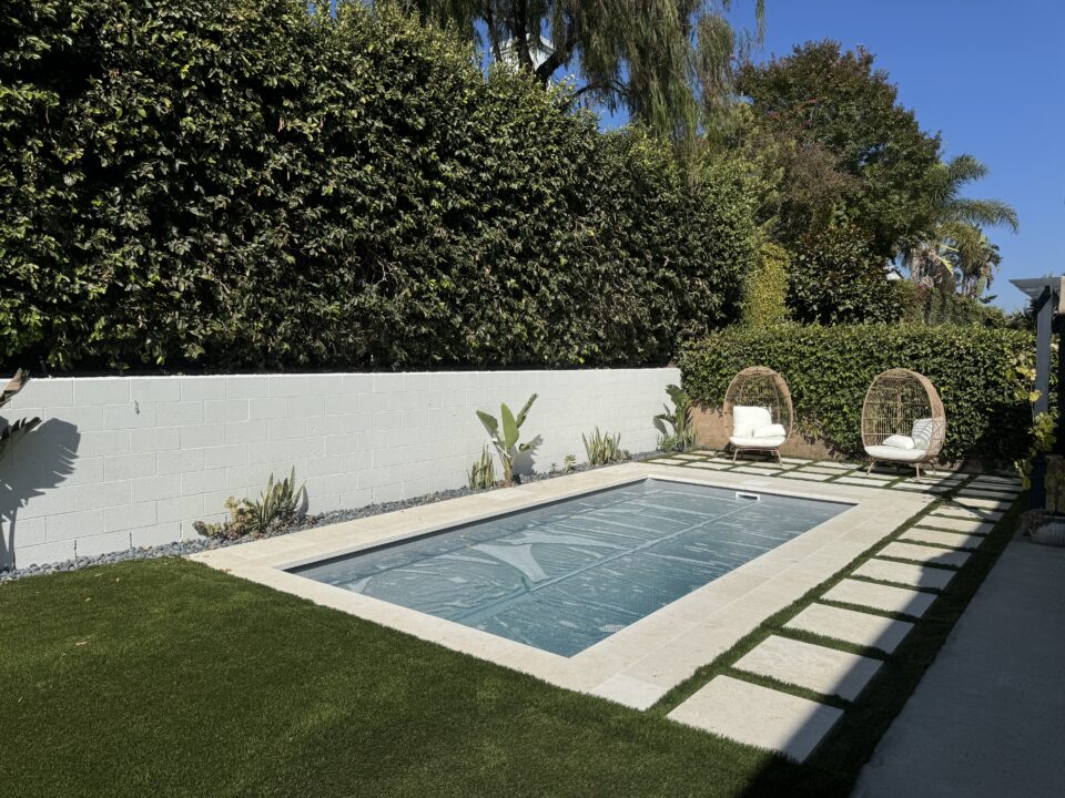 Rectangular plunge pool with a paved patio, wood fence, and separate hot tub in Ventura.