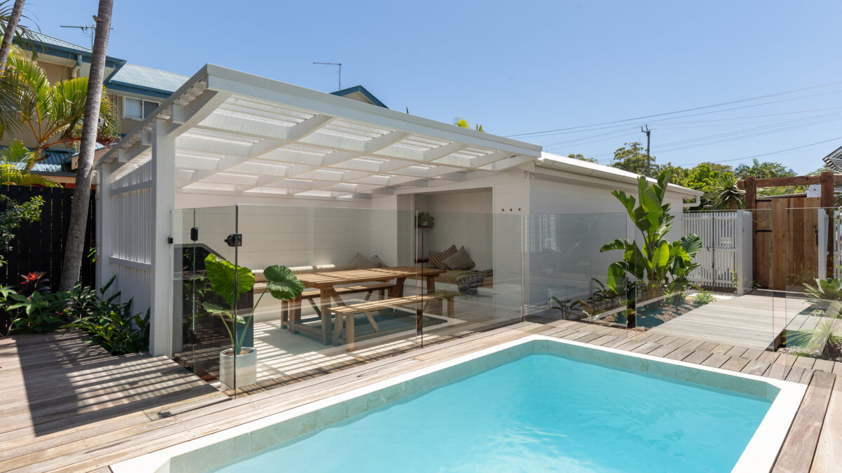 Small rectangular plunge pool beside a covered outdoor dining area and timber deck.